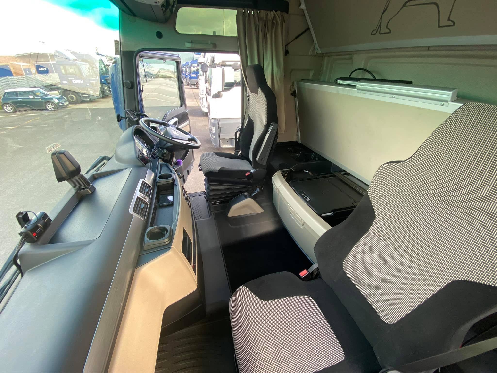 Clean HGV cab interior with dashboard, steering wheel and sleeper area visible